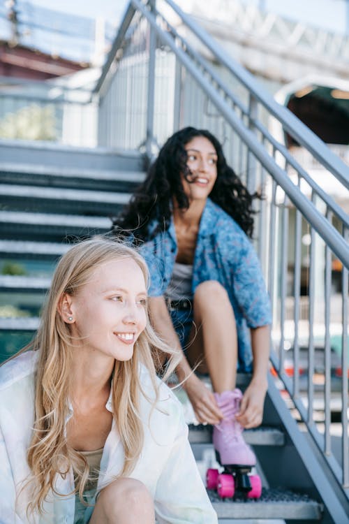 Young Women Sitting on Steps Wearing Roller Skates