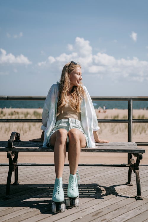 Blonde Girl with Roller Skates Sitting on Bench