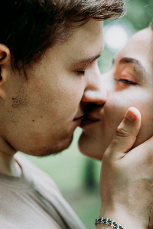 Free Tender moment as a couple kisses passionately outdoors, capturing love and connection. Stock Photo