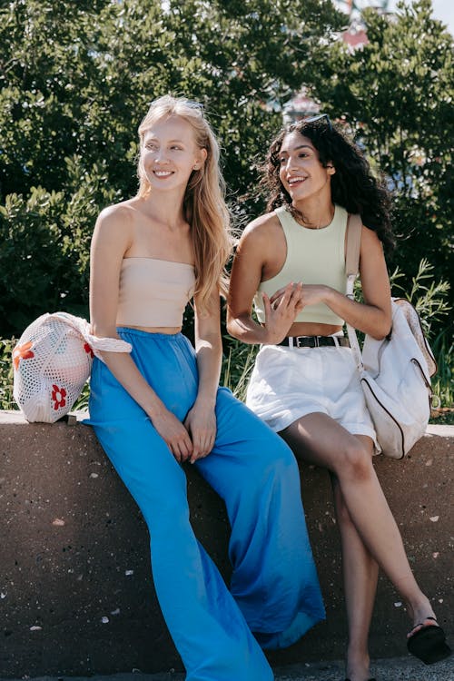 Two Women Sitting on Concrete Surface