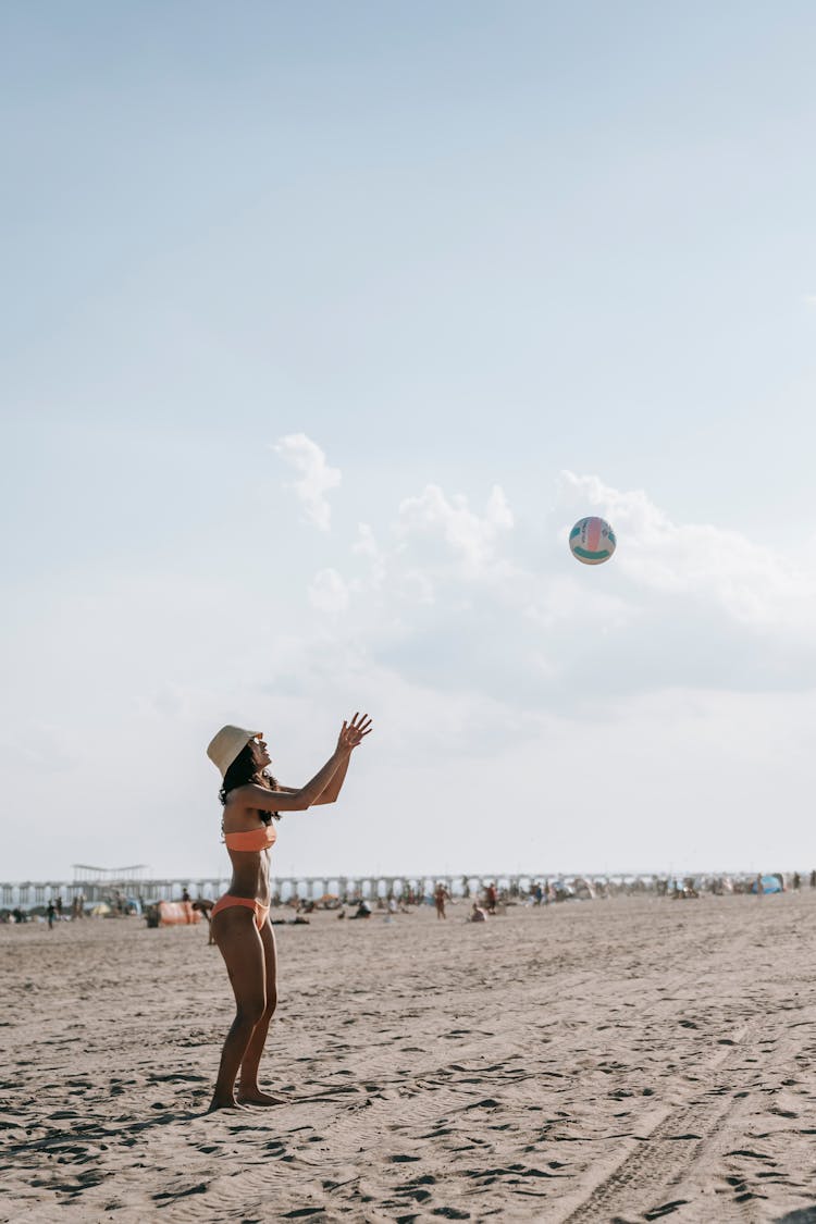 Woman In Orange Bikini Playing Beach Volleyball