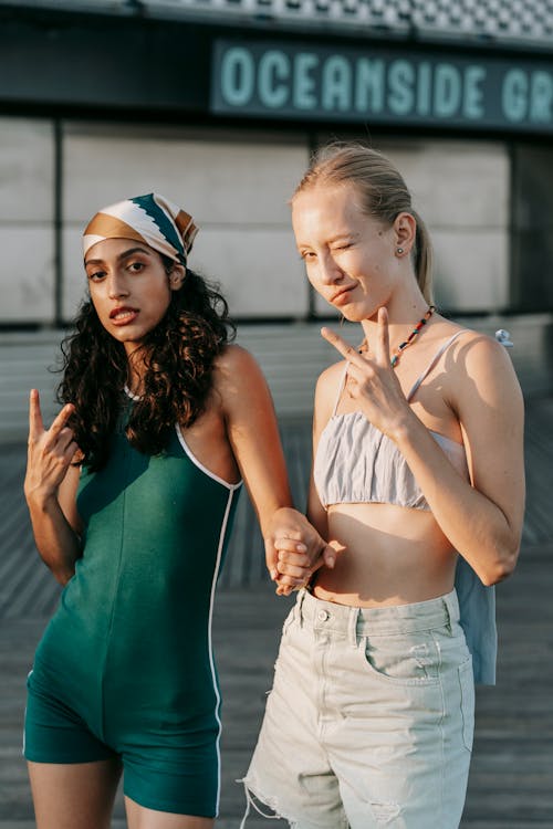 Two Women Holding Hands and Doing a Peace Sign