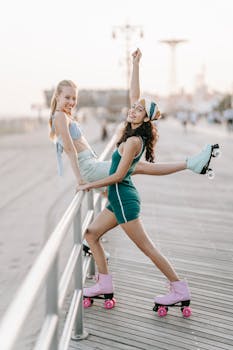 Two women enjoying a summer day roller skating on a beach boardwalk.