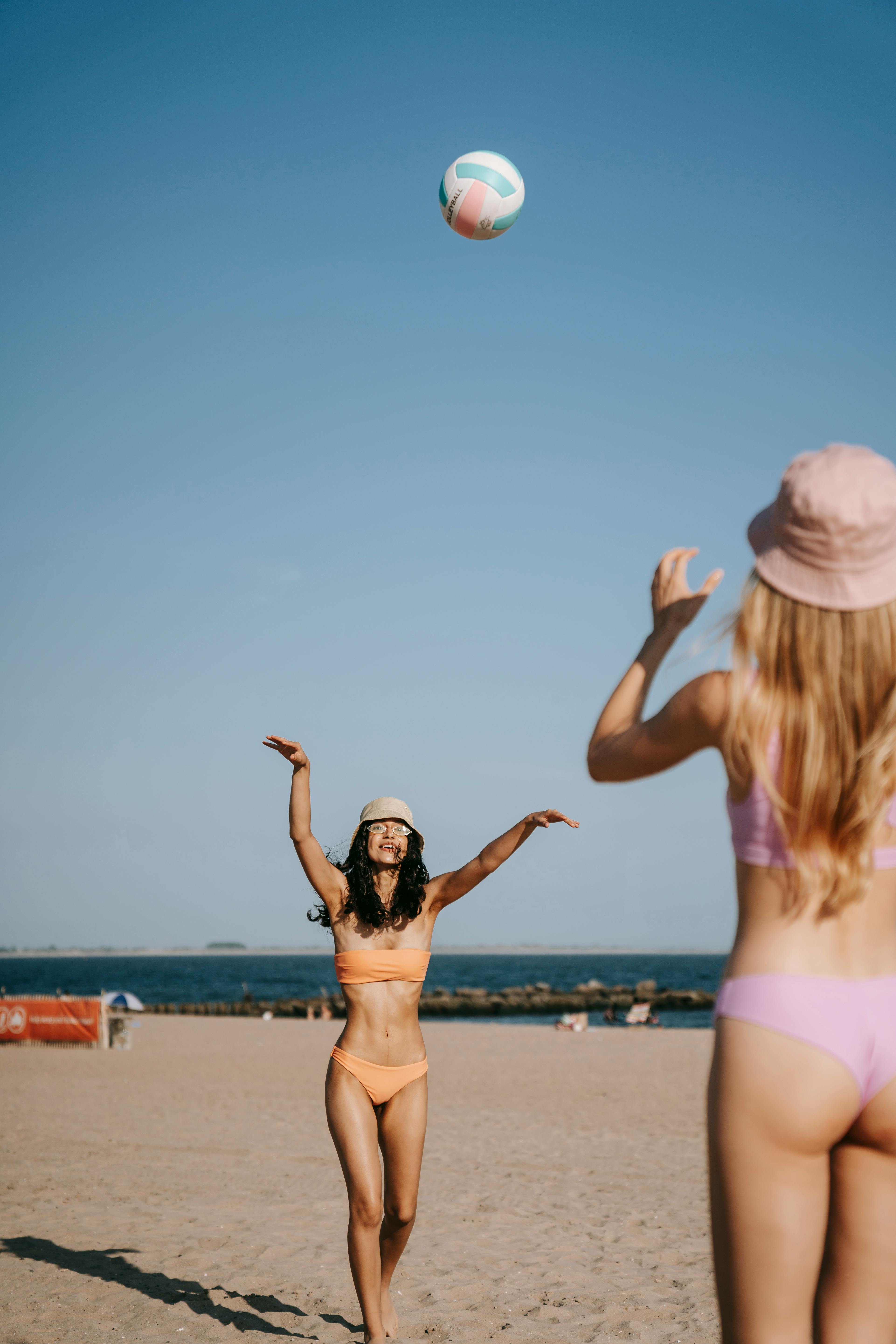 Two Sexy Women in Bikini Playing Volleyball on Beach · Free Stock Photo