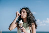 在户外，一名女子品尝着蛋卷冰淇淋