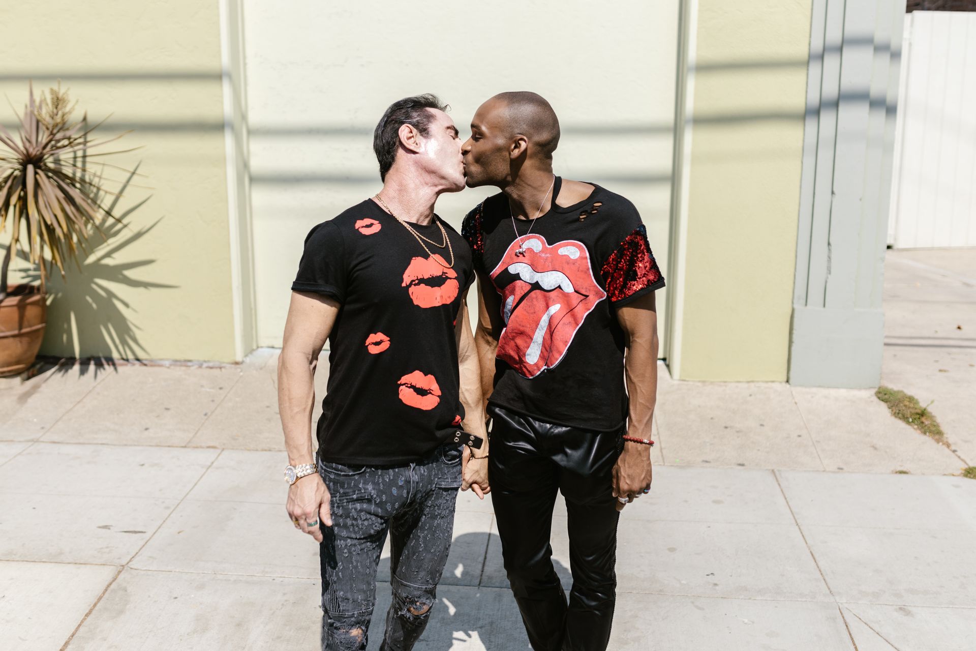 A loving interracial couple sharing a kiss on a sunny day, celebrating diversity and love.