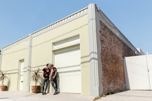 Free Men Kissing in Front of a Building Stock Photo