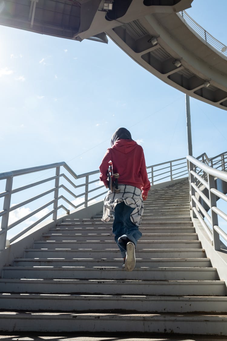 Back View Of A Person Walking On The Staircase