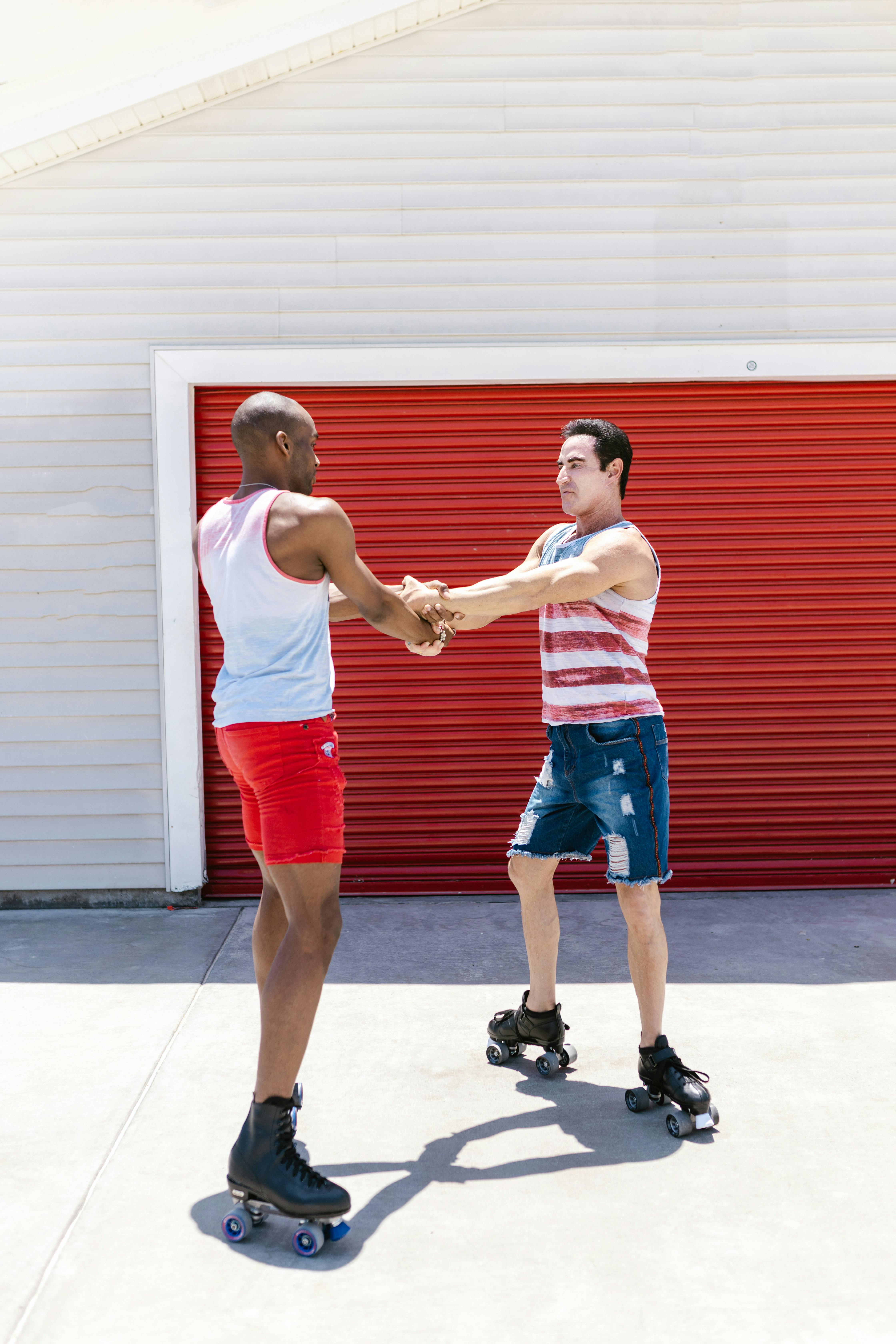 Two men enjoying roller skating together outside, showcasing diversity and fun.