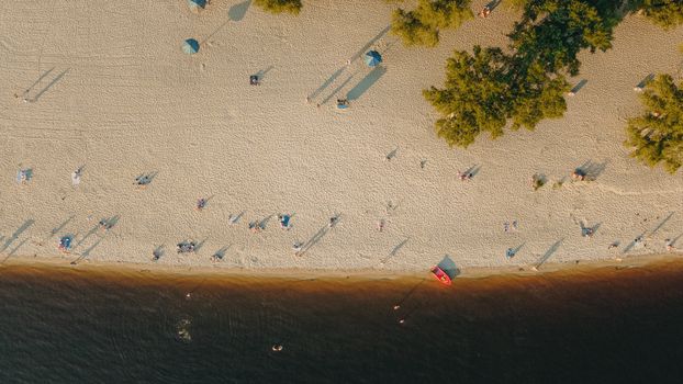 Stunning aerial shot of a summer beach with scattered people and trees in Kyiv, Ukraine.