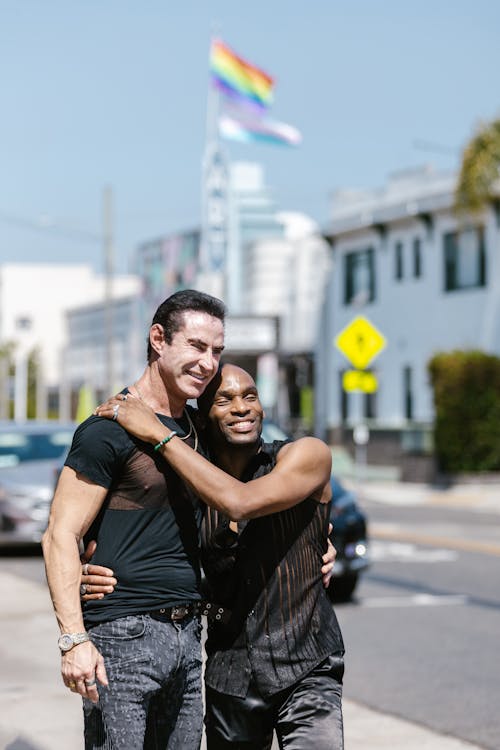 Free A Couple Embracing while Walking on Sidewalk Stock Photo