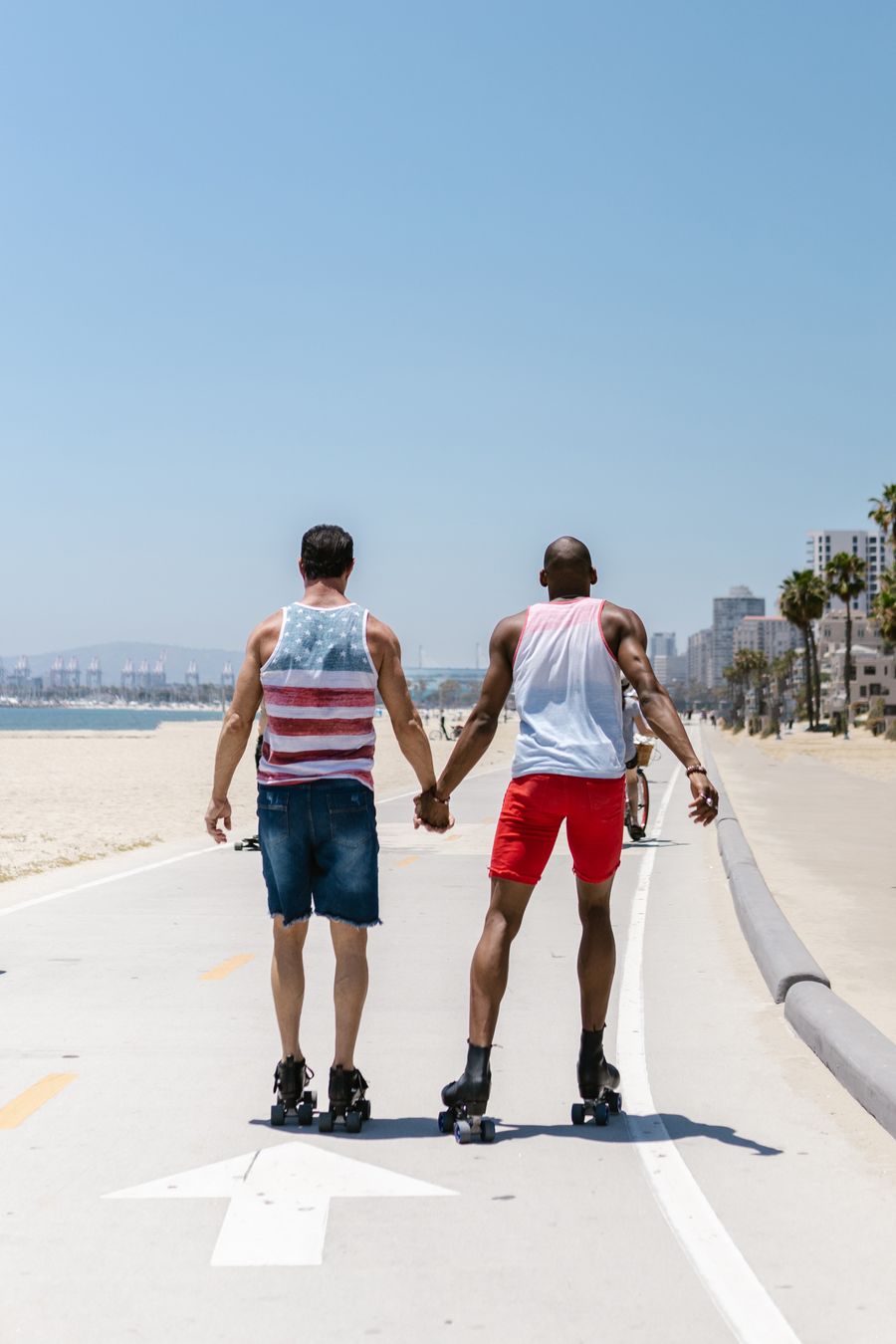 Two friends holding hands while roller skating