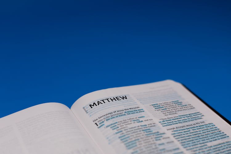 Close-Up Shot Of An Open Bible On A Blue Surface