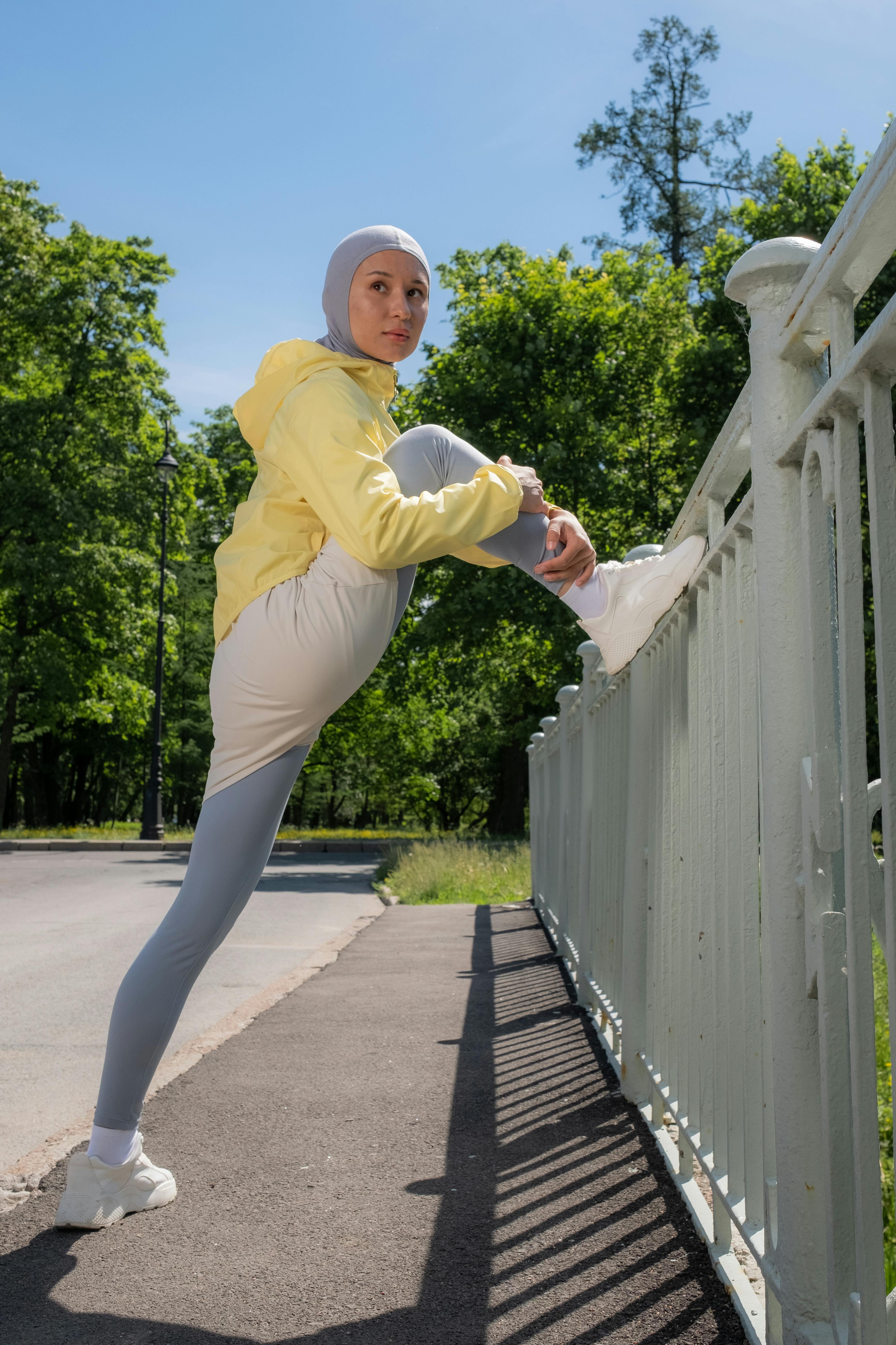 Woman in Yellow Jacket Stretching · Free Stock Photo