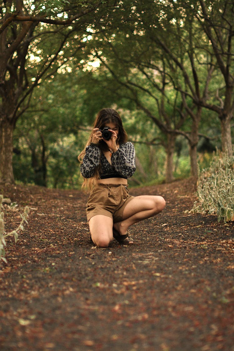 Girl Taking Picture With Camera In Woods