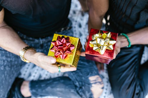Close-Up Shot of Two People Holding Gift Boxes