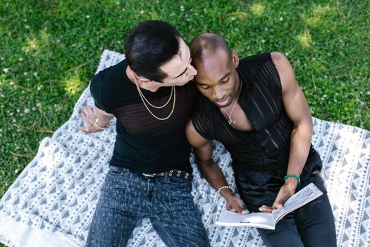 Man in Black Tank Top and Blue Denim Shorts Sitting on Ground Beside Woman in Black