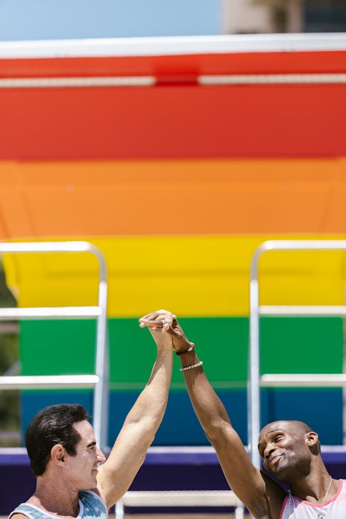 Close Up Photo of Men Holding Hands