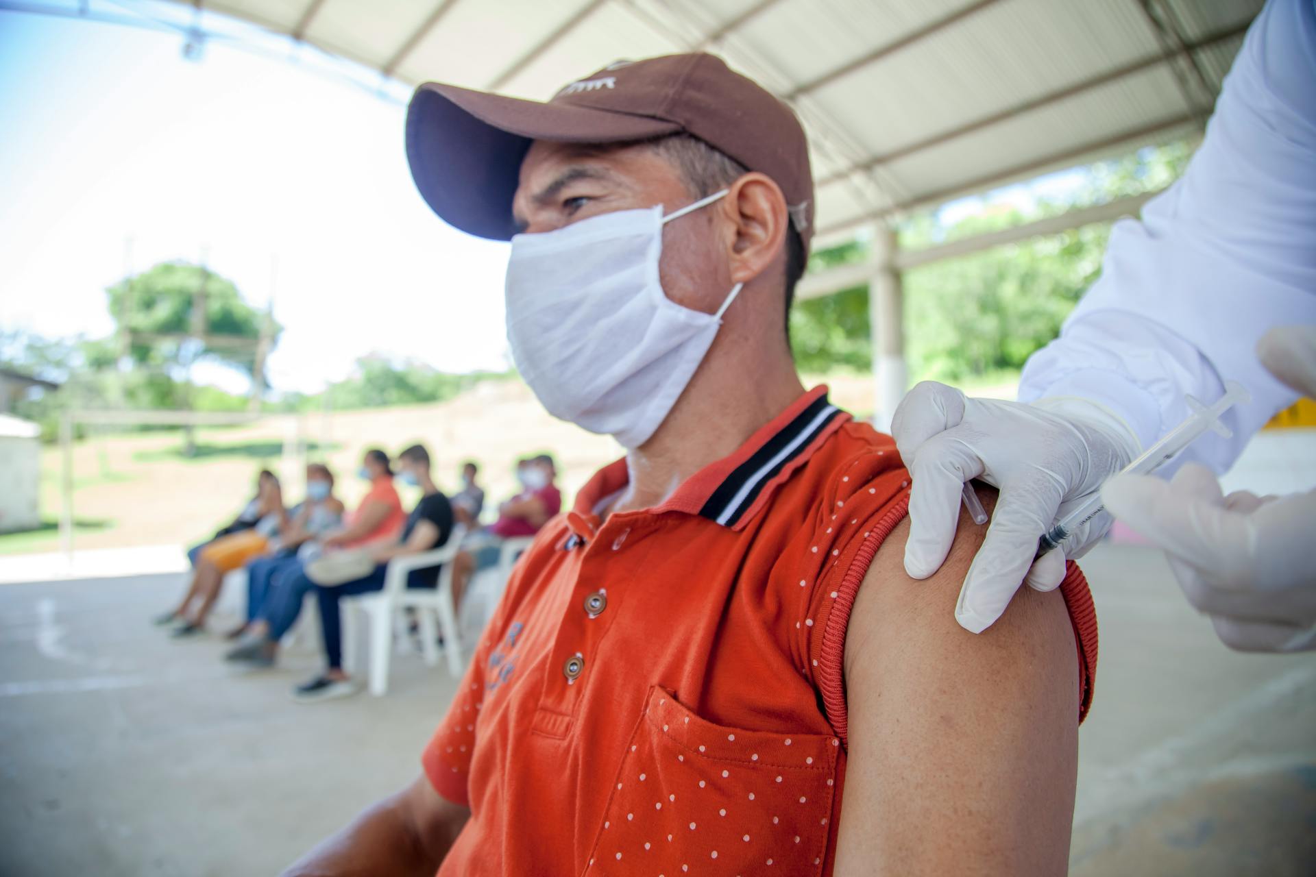 Man in Red Polo Shirt Having Vaccination