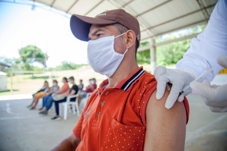 Man In Red Polo Shirt Having Vaccination