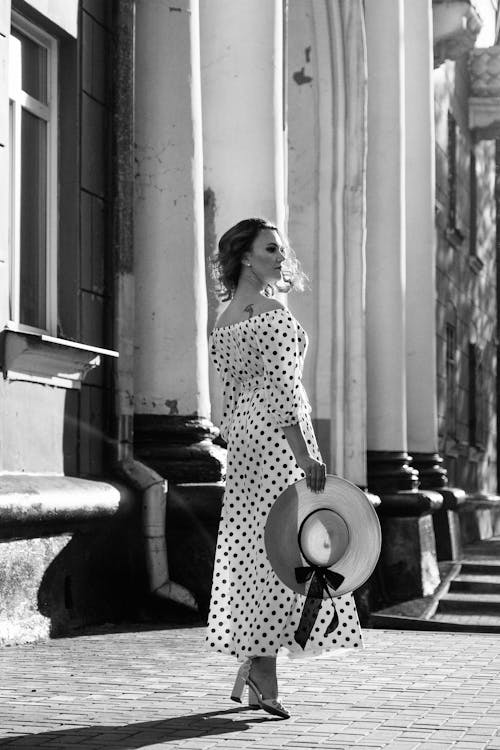 Grayscale Photo of a Woman in Polka Dot Dress Standing