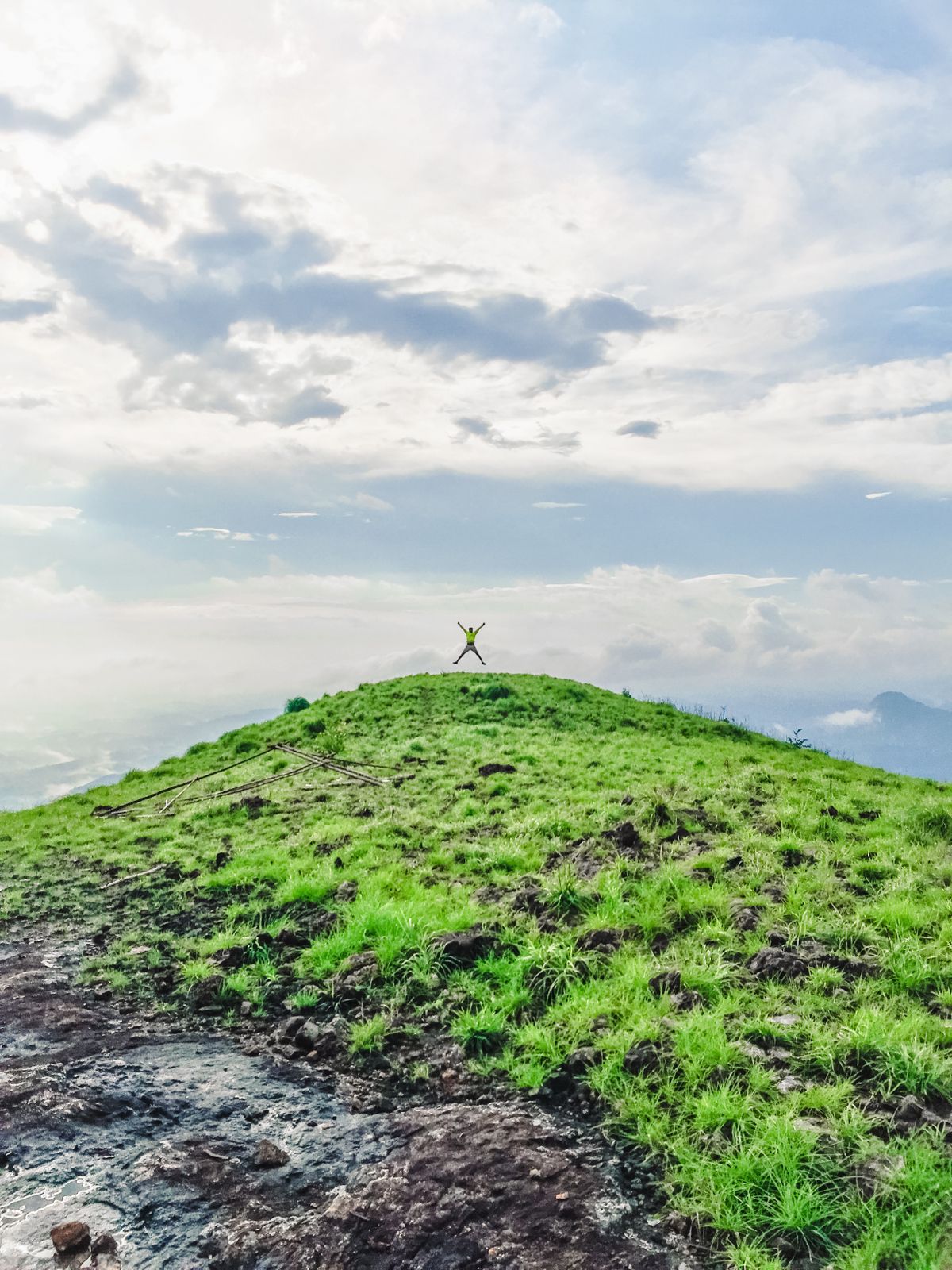 Person sitting on a mountain cliff photographing