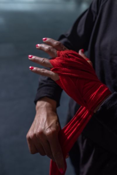 Wrapping hands in red tape, photo by Ron Lach on Pexels