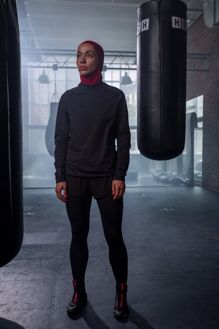 Woman Standing Between Punching Bags