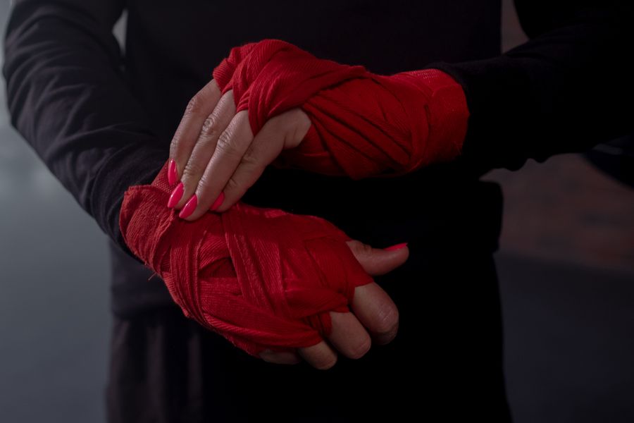 Red boxing hand wraps being wrapped around a hand