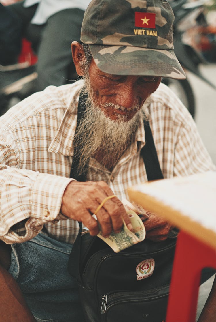 An Elderly Man Counting His Money