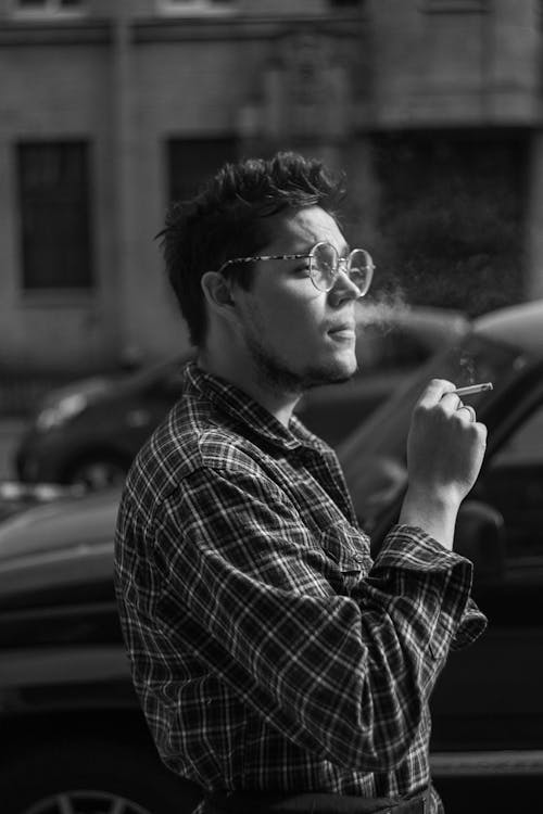 Grayscale Photo of a Man with Sunglasses Smoking a Cigarette