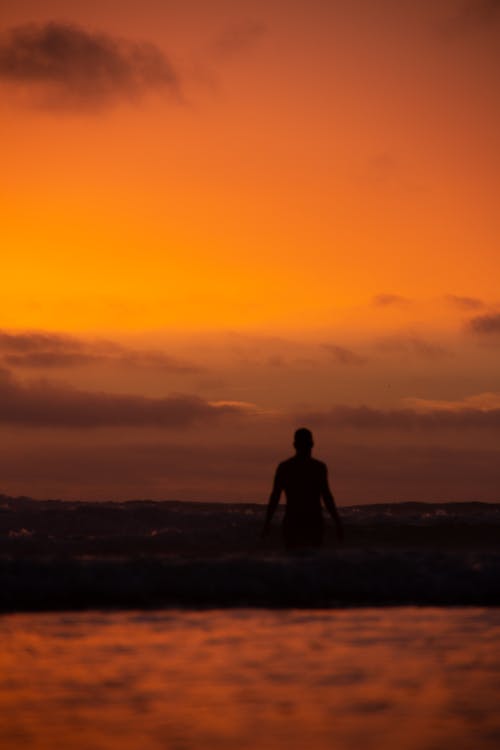 Silhouette of a Person Standing on the Beach