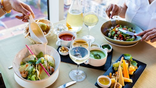 Wine Glasses and Bowls of Salad on a Wooden Table