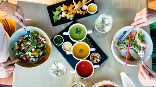 Free Vibrant vegetarian dining setting featuring assorted soups and fresh salads for a healthy meal. Stock Photo