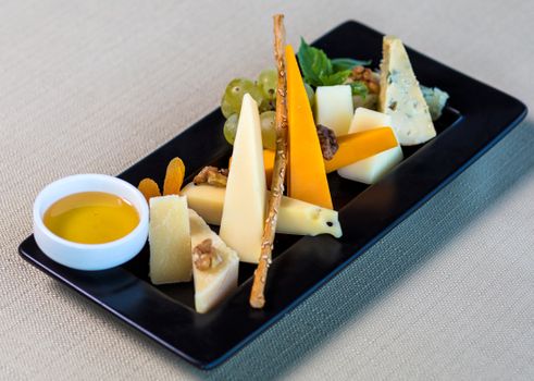 A visually appealing cheese platter featuring various cheeses, nuts, and fruits in a close-up shot.