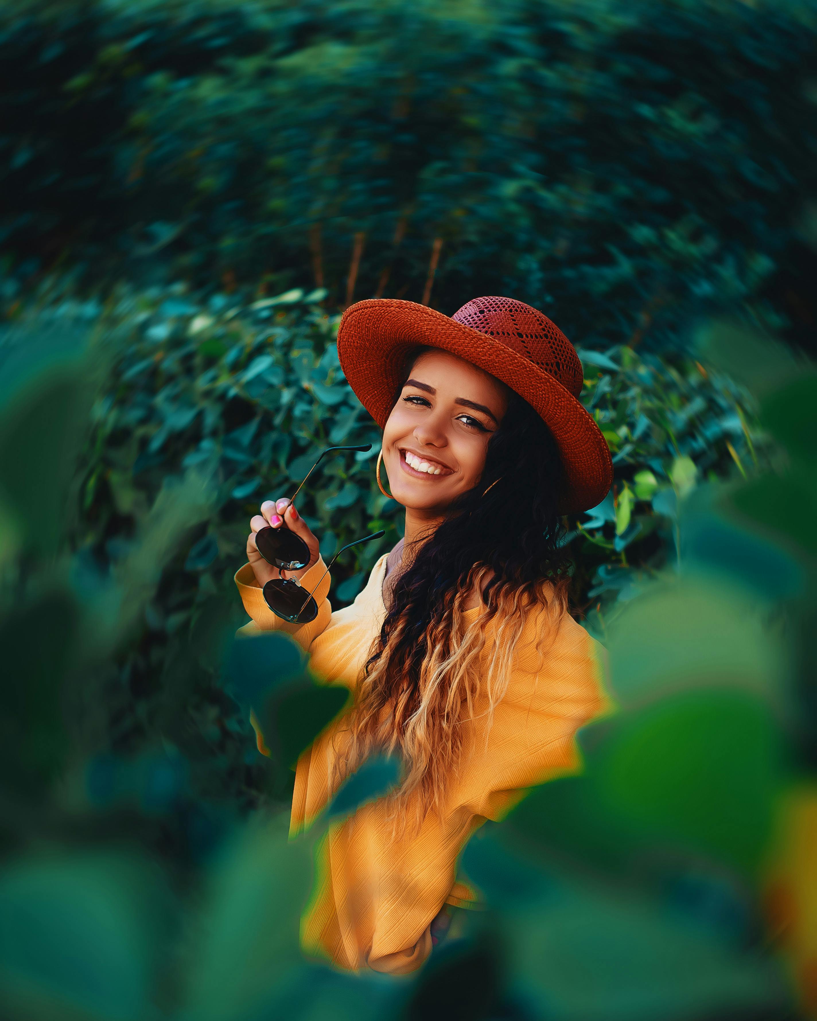 Woman Wearing Gray Sun Hat in Front of White Fence · Free Stock Photo