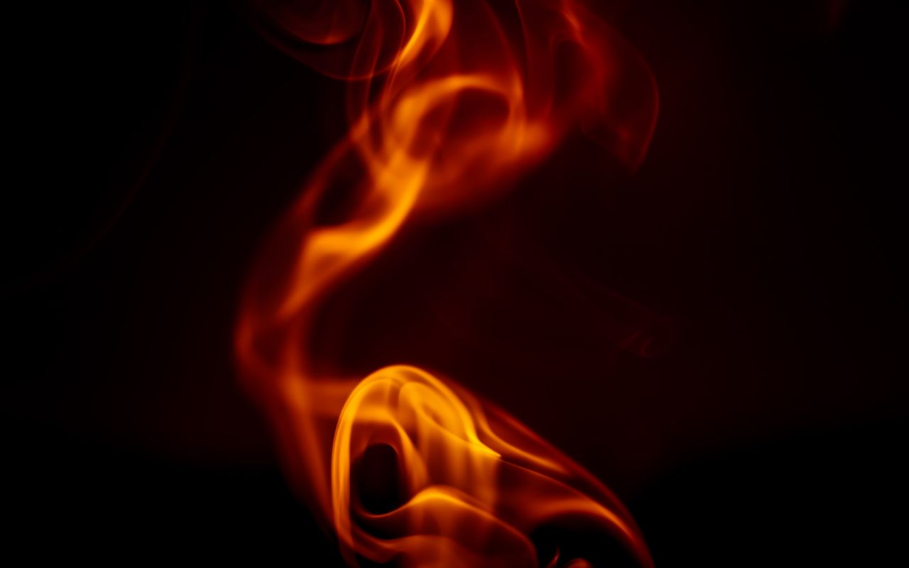 dynamic orange flames create a striking abstract pattern on a dark bac