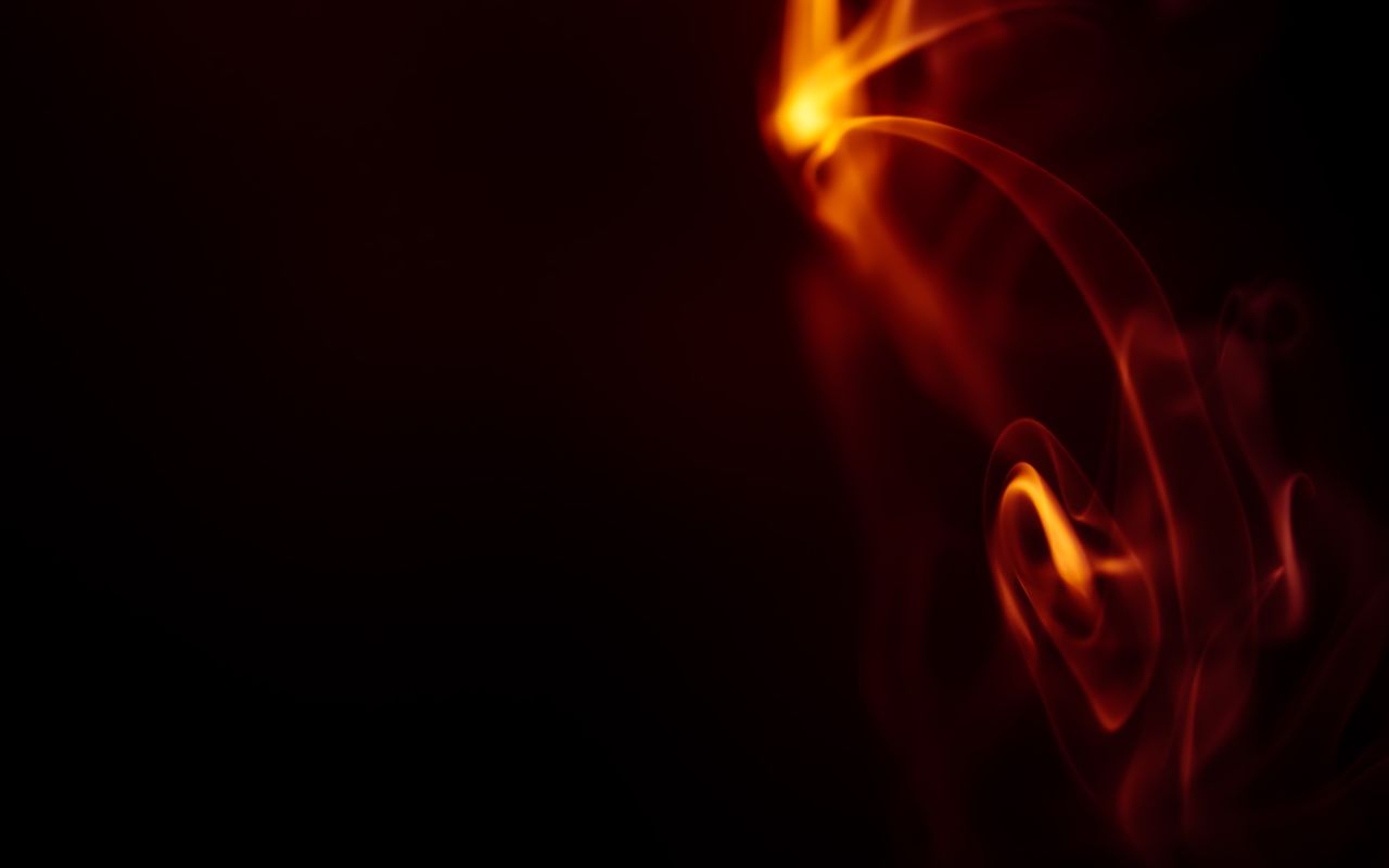 close up of swirling fire and smoke with dark background creating a vi