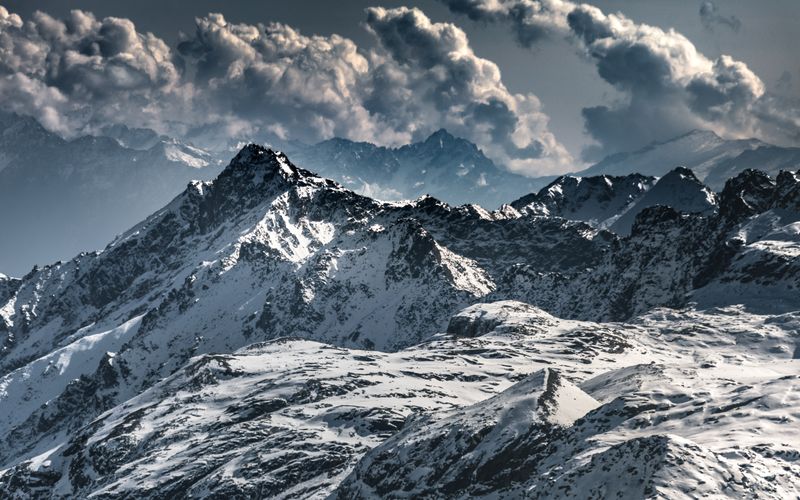 Snow-covered mountain range under dramatic cloud — photo by Marek Piwnicki on Pexels