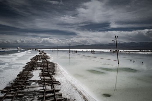 A captivating scene at Chaka Salt Lake in China featuring a railway and stunning sky reflection.