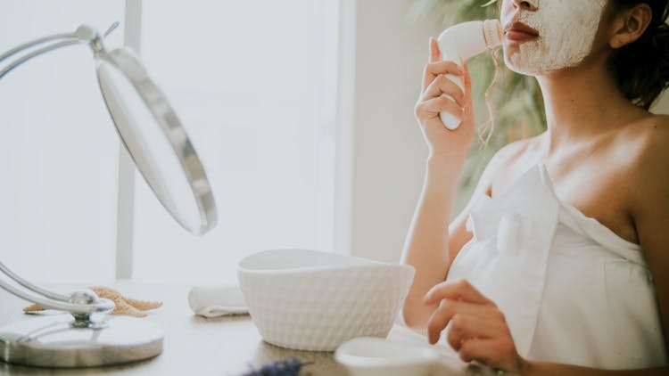 A Woman Using A Facial Cleansing Brush