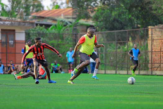 Two soccer players in action during a friendly match on a lush green field.