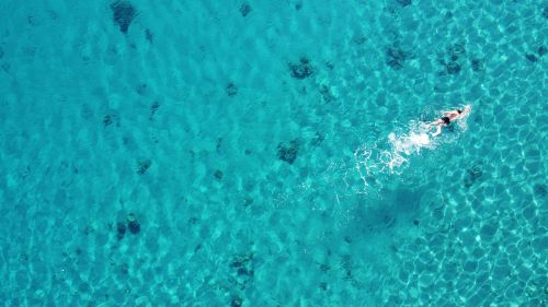 Free A swimmer enjoys the clear turquoise waters of Eilat, Israel, viewed from above. Stock Photo