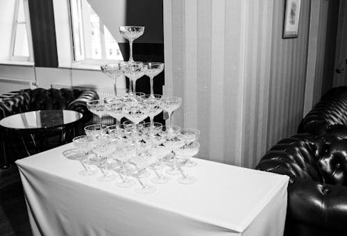 Free Grayscale Photo of a Stack of Wine Glasses on a Table Stock Photo