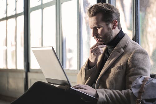 Mann, Der Braune Jacke Trägt Und Grauen Laptop Benutzt