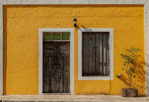 Wooden Door and Window on a Yellow Concrete Wall