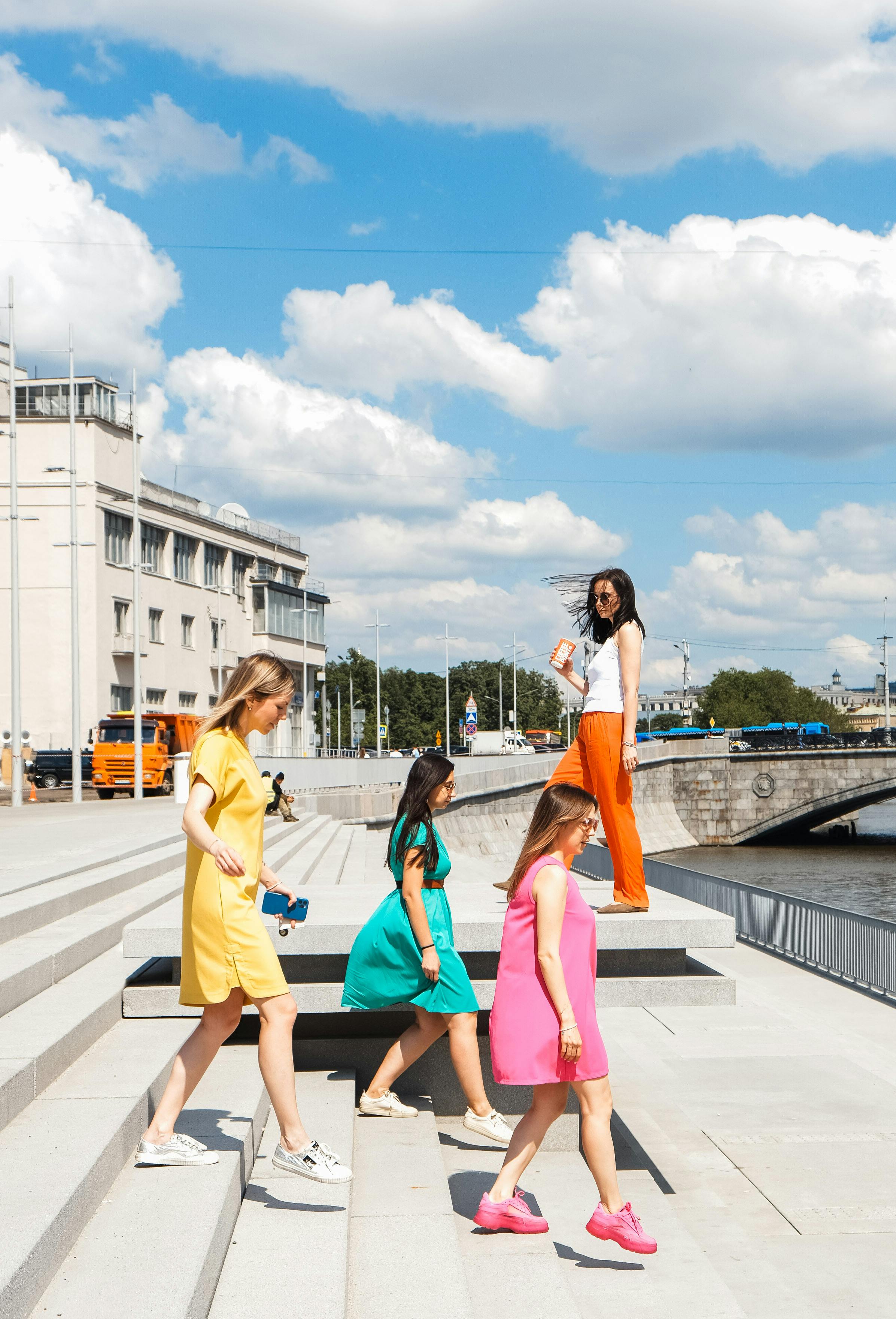 women in colorful dresses walking down the concrete stairs