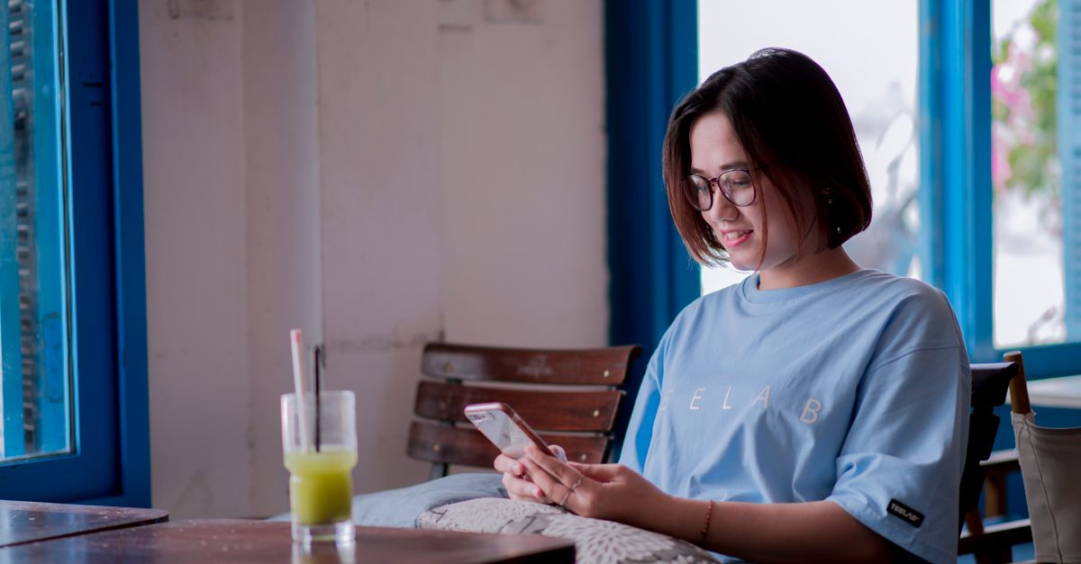 A person looking relieved while reading supportive comments on a smartphone