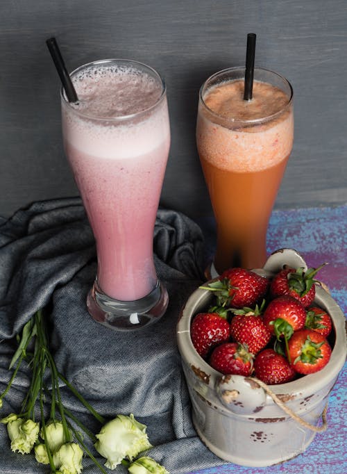 Strawberry Juice in Drinking Glass Near Fresh Strawberries in a Container