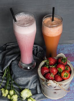 Top-down view of strawberry smoothies in glasses with fresh strawberries, perfect for a healthy lifestyle.